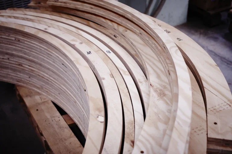 Pezzi di legno curvati a forma di C su un piano di lavoro
